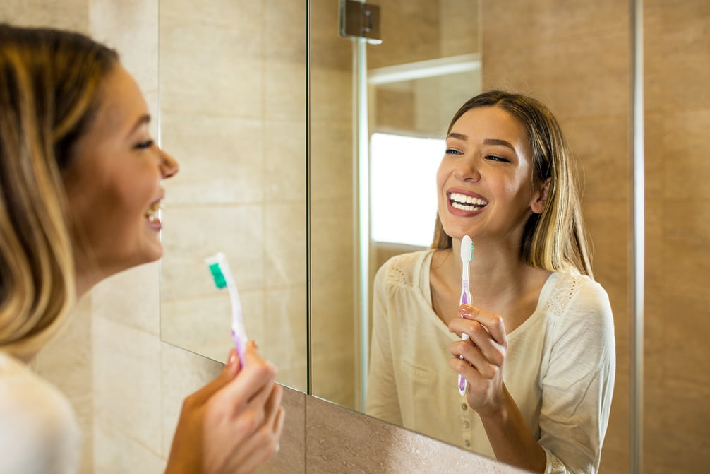 young woman cleaning teeth